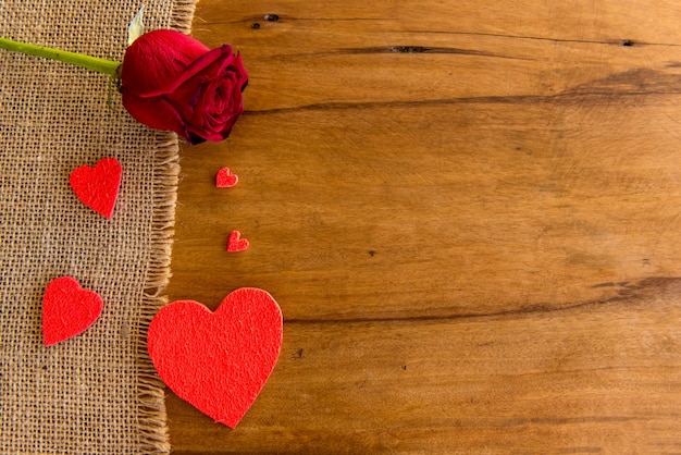 Corações de conceito de dia dos namorados e rosa na mesa de madeira