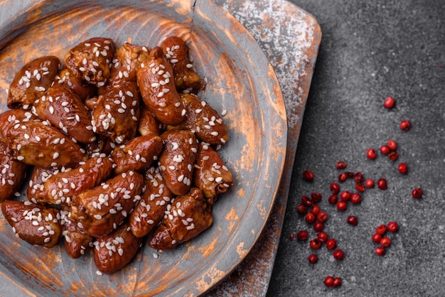 Corações de frango fritos em molho de soja com sal e especiarias num prato