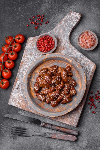 Corações de frango fritos em molho de soja com sal e especiarias num prato