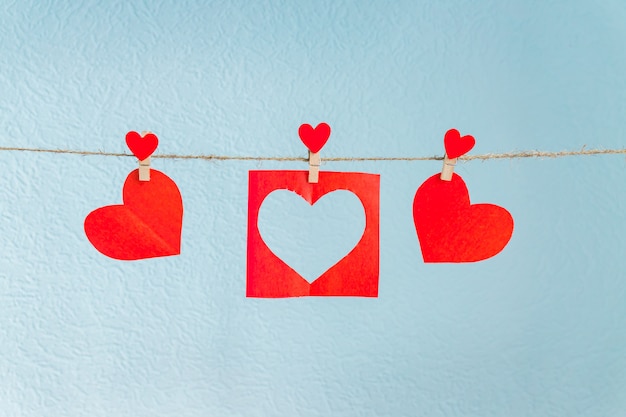 Foto corações de papel amor pendurado na corda em um fundo azul