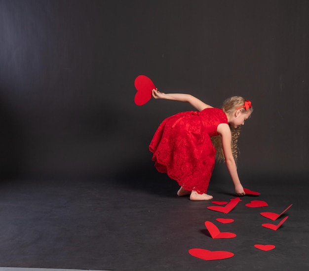 Corações de papel Dia dos namorados placa corações no chão a fórmula de espaço de cópia de formulário de férias de noivado de amor em uma menina de vestido vermelho com os pés descalços