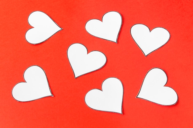 Foto corações de papel em um fundo vermelho. dia dos namorados. cartão de dia dos namorados