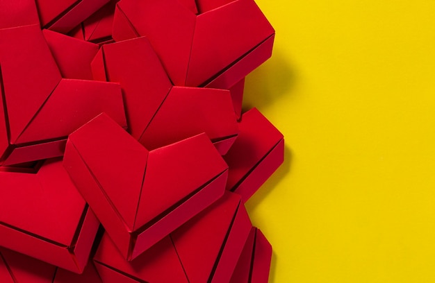 corações de papel vermelho sobre fundo amarelo, o conceito de amor, o dia de São Valentim, origa vermelha