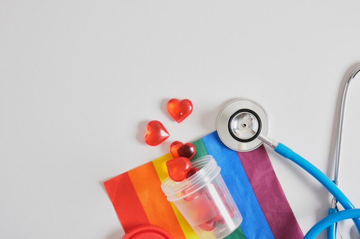 Foto corações em um banco de teste, estetoscópio médico e bandeira da comunidade lgbtq em um espaço de cópia de fundo cinza, doação de espermatozoides e óvulos para casais gays, inseminação artificial, barriga de aluguel