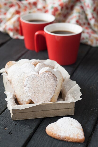 Corações vermelhos de copo e biscoito