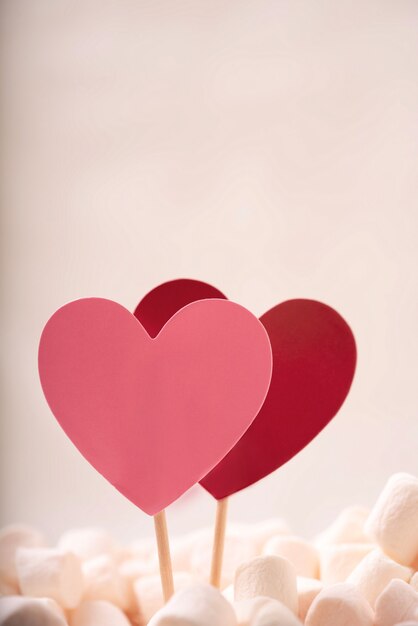 Corações vermelhos e rosa em marshmallow na parede branca. Conceito de São Valentim. Fechar-se