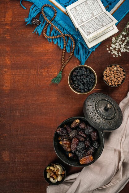 Corán abierto cerca de las fechas concepto de ramadan kareem sobre fondo de madera oscura