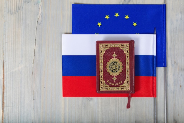 Corán y helicóptero en banderas de la UE y Rusia