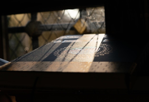 Corán o Kuran, el libro sagrado islámico sobre el brillo del sol, fondo negro, fondo de Ramadán
