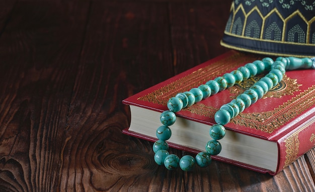 Corán y rosario en mesa de madera