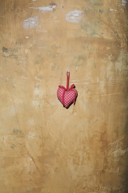 Corazón abstracto del día de San Valentín en la pared con textura amarilla, espacio de copia