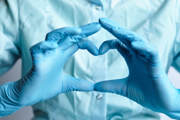 El corazón abstracto hace que la mano del médico en guantes médicos.