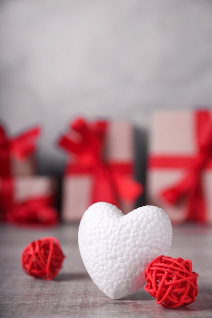 Corazón blanco, adornos rojos y cajas de regalo.