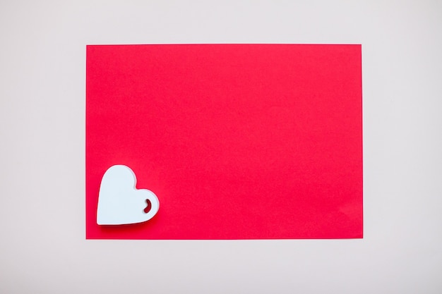 Foto corazón blanco en una hoja a4 roja en blanco