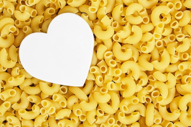 Corazón blanco sobre fondo de pasta