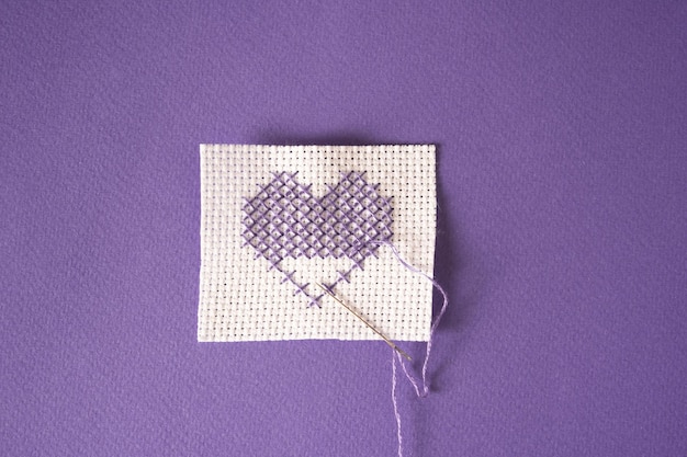 Corazón de bordado sobre fondo morado