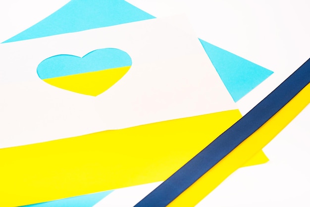 Corazón cortado de papel y pintado en colores azul y amarillo y cinta de bandera Creatividad como apoyo a Ucrania