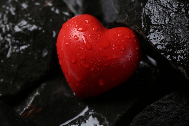 Corazón decorativo rojo en piedras en primer plano
