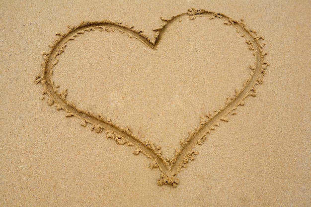 Foto corazón dibujado en la arena para el día de san valentín