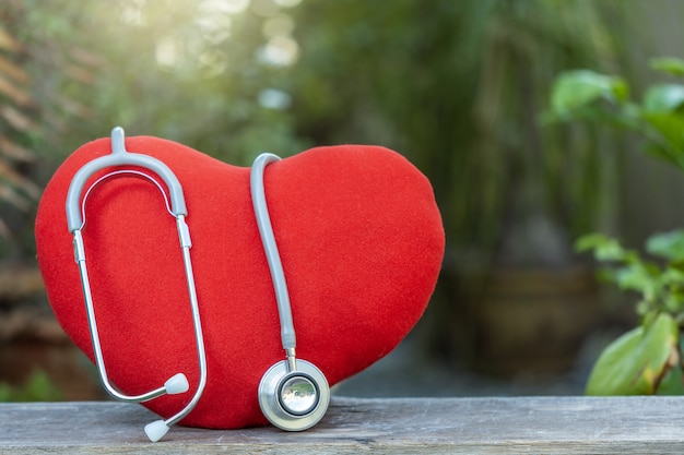 Corazón con estetoscopio médico en la naturaleza borrosa