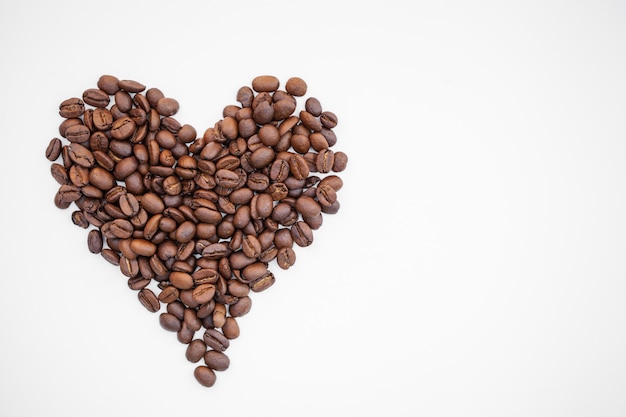 Corazón de granos de café aislado en blanco