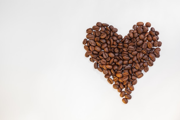 Corazón de granos de café aislado en blanco