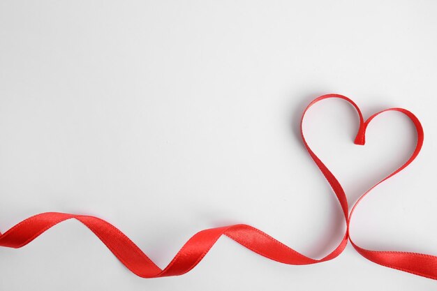 Corazón hecho de cinta roja sobre fondo blanco vista superior Celebración del día de San Valentín