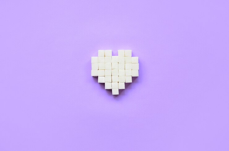 Foto un corazón hecho de cubos de azúcar se encuentra en una violeta pastel de moda