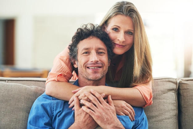 El corazón de un hogar es el amor Retrato de una feliz pareja madura pasando un día relajado juntos en casa