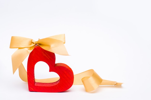 Corazón de madera con un arco en un fondo blanco. día de San Valentín