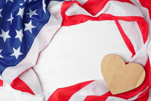 Corazón de madera y bandera estadounidense sobre fondo claro Vacaciones en Estados Unidos