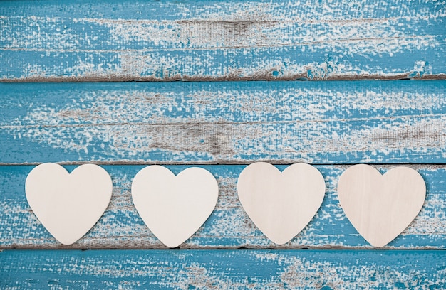 Corazón de madera en el fondo de madera azul vintage.