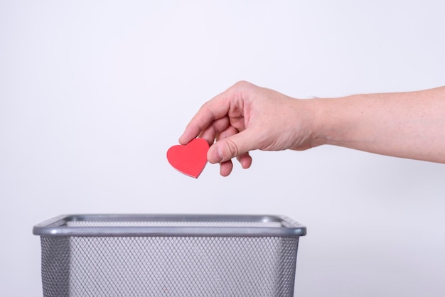 Corazón de madera hecho a mano tirado a la basura para su reciclaje y eliminación