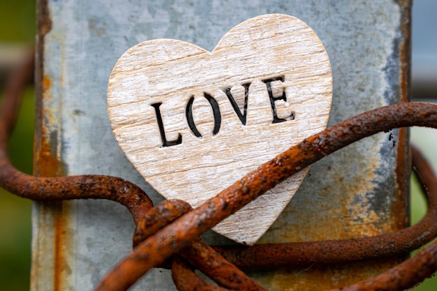 Foto corazón de madera con las letras amor sobre un fondo de metal rústico corazones sobre fondo de madera escuchar