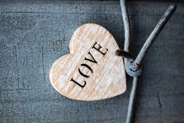 Foto corazón de madera con las letras amor sobre un fondo de metal rústico corazones sobre fondo de madera escuchar