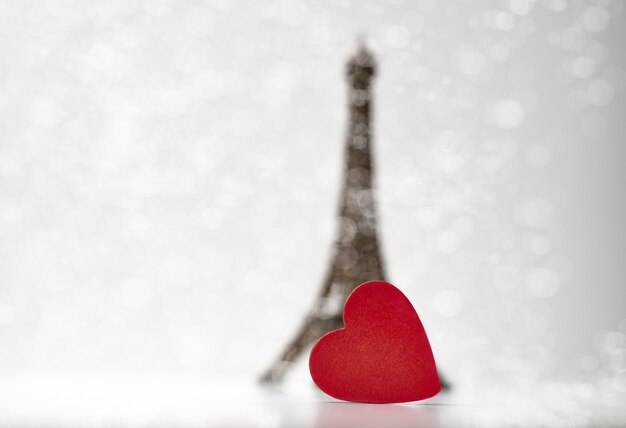 Corazón de madera roja frente a la pequeña Torre Eiffel. Concepto de San Valentín.