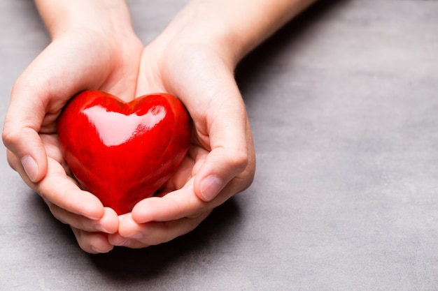 Corazón de madera roja en manos de niño