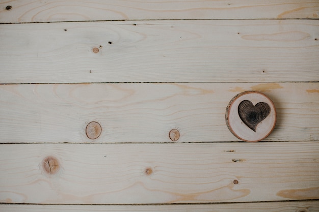 Corazón de madera sobre fondo de madera.