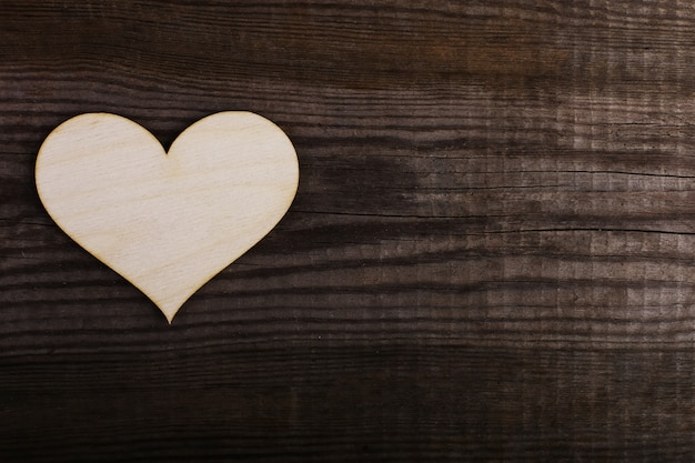 Foto corazón de madera sobre la mesa vieja