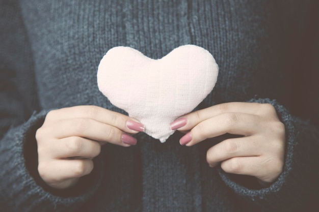 Corazón en la mano de la mujer en estudio