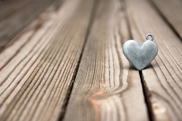 Corazón de metal sobre fondo de madera feliz día de San Valentín en el amor