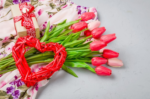 Corazón de mimbre, caja de regalo y tulipanes.