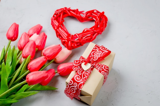 Corazón de mimbre, caja de regalo y tulipanes.