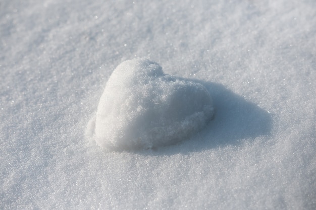 Corazón de nieve en el espacio de nieve de invierno
