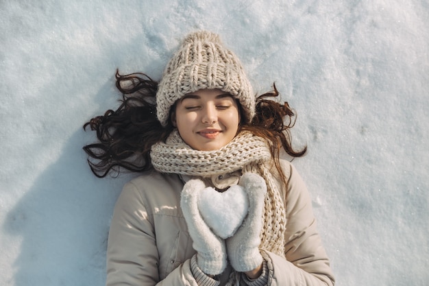 Corazón de nieve en manos de una mujer