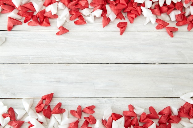 Corazón de papel blanco y rojo sobre madera.