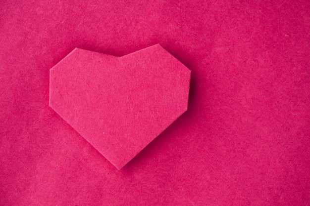 Corazón de papel hecho a mano sobre papel kraft como fondo. Coche de saludo. Espacio libre para texto
