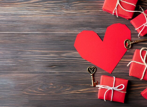 Corazón de papel rojo y llave antigua sobre un fondo de madera oscura Día de San Valentín Copiar espacio