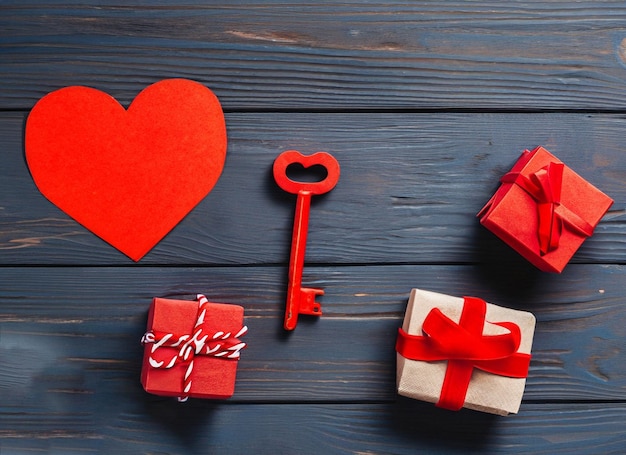 Corazón de papel rojo y llave antigua sobre un fondo de madera oscura Día de San Valentín Copiar espacio