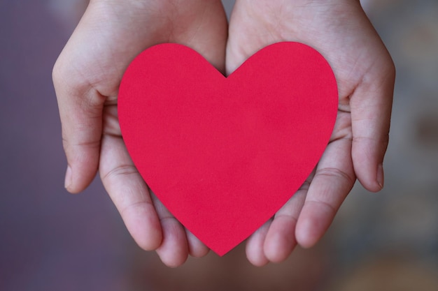 Corazón de papel rojo a mano en el concepto de amor y día de san valentín